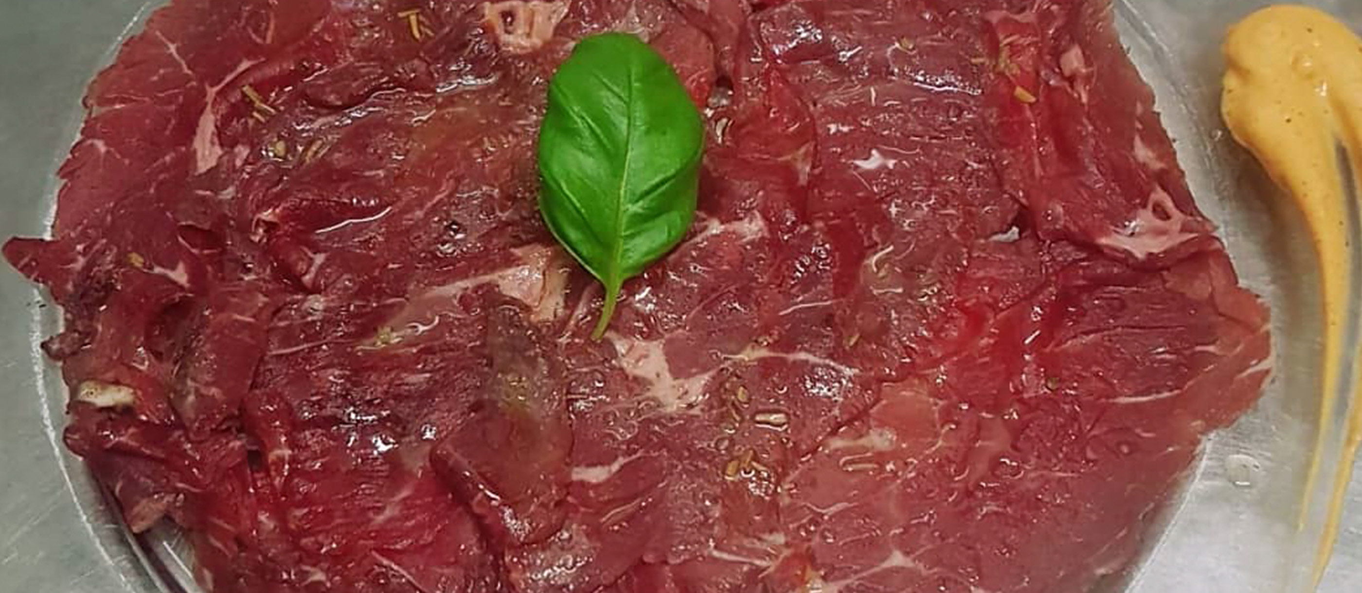 italian dish of thin slices of raw meat